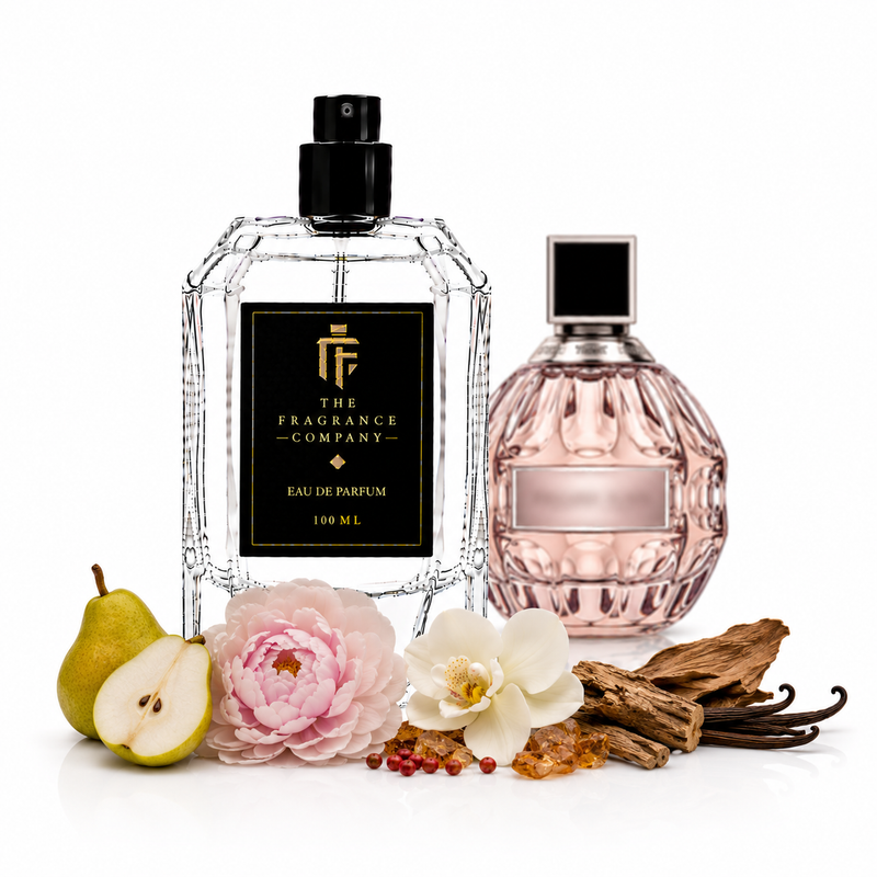 Two perfume bottles from The Fragrance Company on a white background, styled with pear halves, pink and white flowers, vanilla pods, and amber beads. The left bottle is clear faceted glass with a black spray top and black label.