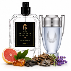 A clear glass perfume bottle with a black spray top and a black label reading 'THE FRAGRANCE COMPANY' is shown alongside a silver-toned cylindrical decanter or container. The bottle is styled with citrus, herbs, and purple flowers on a white background.