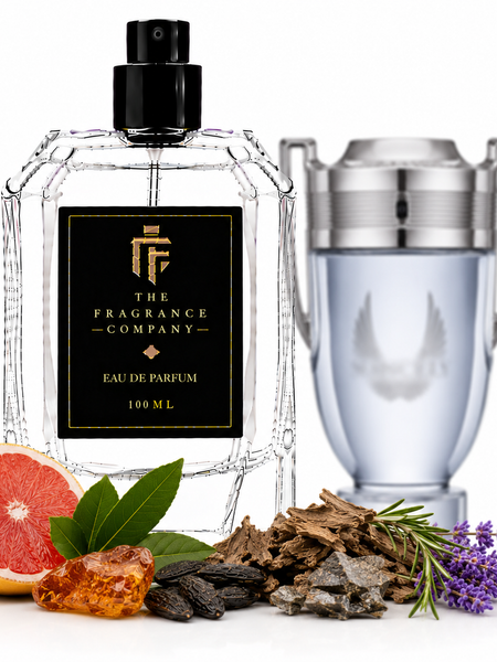 A clear glass perfume bottle with a black spray top and a black label reading 'THE FRAGRANCE COMPANY' is shown alongside a silver-toned cylindrical decanter or container. The bottle is styled with citrus, herbs, and purple flowers on a white background.