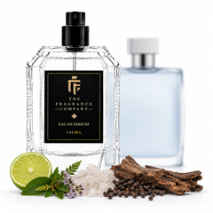 A 100ml clear glass perfume bottle with a black label and black spray cap from The Fragrance Company, styled with a light blue bottle in the background and scent ingredients including a lime slice, rosemary, sea salt, and wood pieces on a white background.